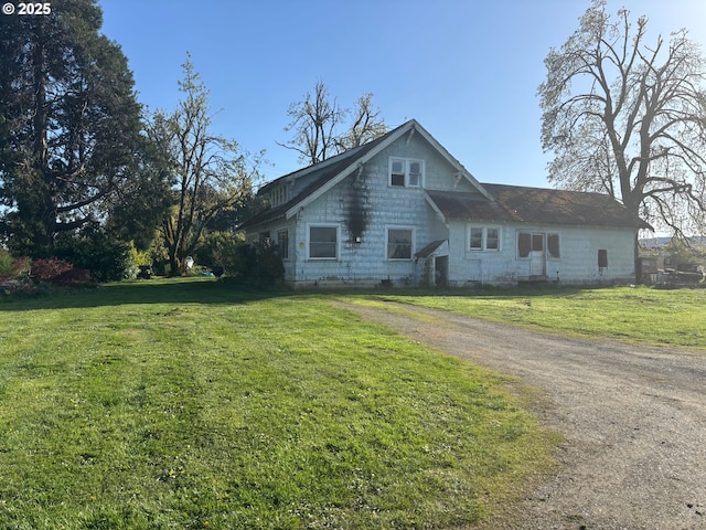 view of front of house featuring a front lawn and dirt driveway