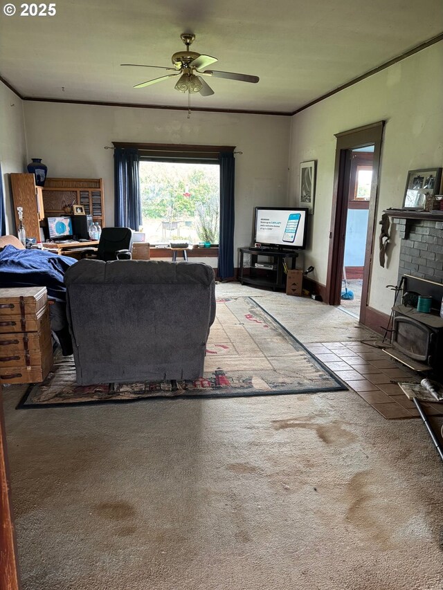 living area featuring a wood stove, a ceiling fan, plenty of natural light, and carpet
