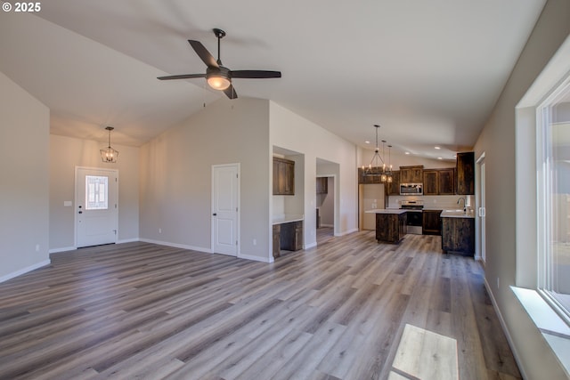 113 Citation Ct, Winston, OR 97496 - unfurnished living room featuring a chandelier, a sink, vaulted ceiling, light wood-type flooring, and baseboards