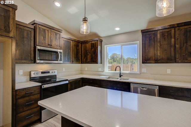 113 Citation Ct, Winston, OR 97496 - kitchen with stainless steel appliances, a sink, dark brown cabinetry, light countertops, and hanging light fixtures