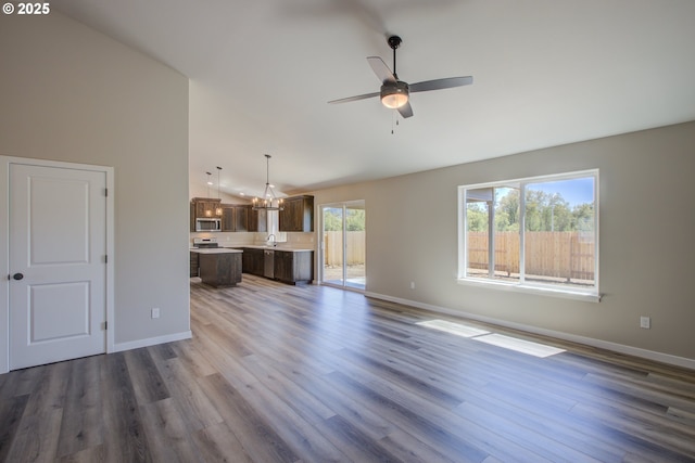 113 Citation Ct, Winston, OR 97496 - unfurnished living room with vaulted ceiling, baseboards, ceiling fan, wood finished floors, and a sink