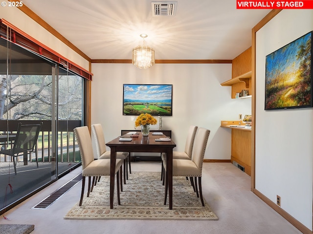 carpeted dining space with ornamental molding, a wealth of natural light, and a chandelier