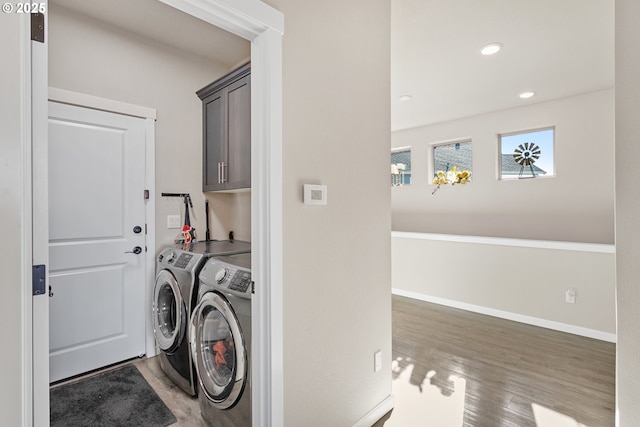 laundry area with recessed lighting, wood finished floors, washing machine and dryer, baseboards, and cabinet space
