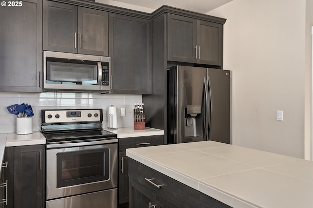 kitchen featuring light countertops, backsplash, and appliances with stainless steel finishes