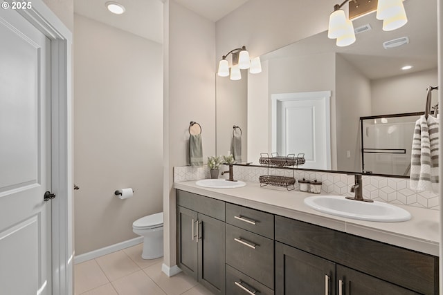 bathroom with backsplash, toilet, a sink, and double vanity