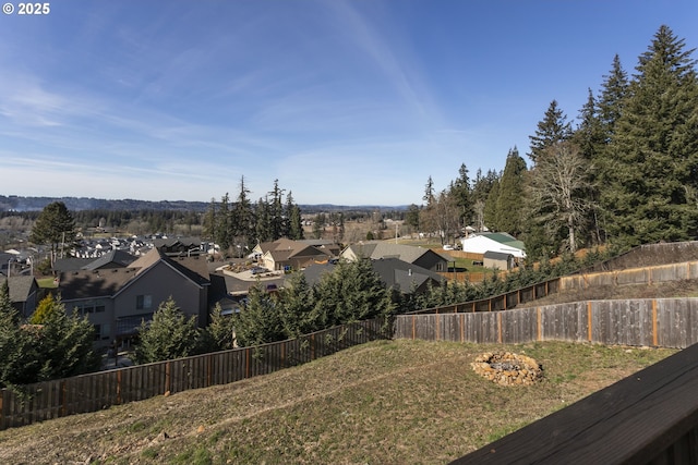 view of yard with a fenced backyard, an outdoor fire pit, and a residential view