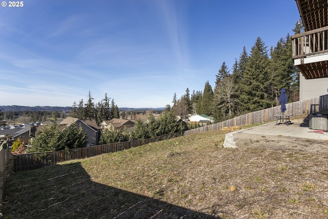 view of yard with a fenced backyard, central air condition unit, and a patio