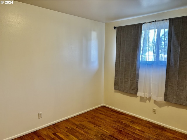 unfurnished room with dark wood-type flooring