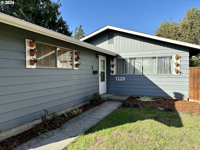 view of exterior entry with a yard