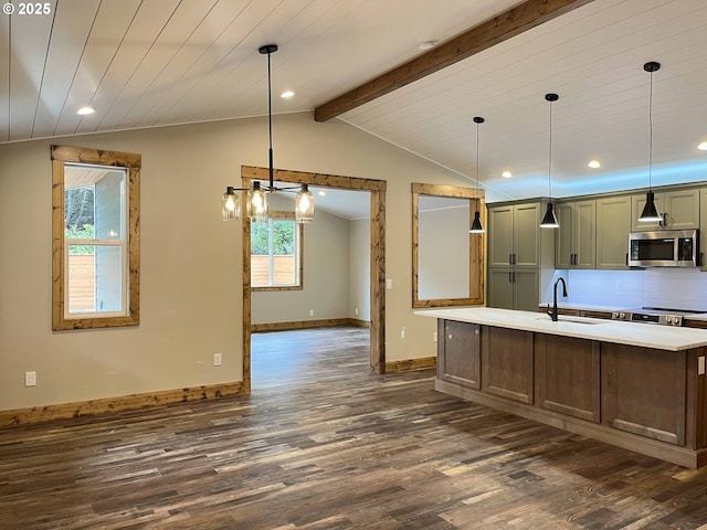 88366 4th Ave, Florence, OR 97439 - kitchen with dark wood-style flooring, a sink, baseboards, stainless steel microwave, and vaulted ceiling with beams