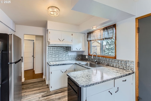 kitchen with beverage cooler, a sink, freestanding refrigerator, white cabinets, and white electric stovetop