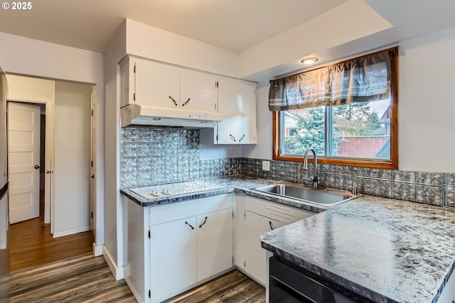 kitchen with under cabinet range hood, white cabinetry, dark wood finished floors, and a sink