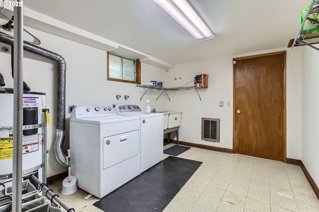 laundry area featuring washing machine and dryer, baseboards, light floors, secured water heater, and laundry area