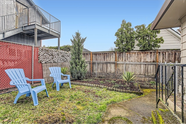 view of yard with a balcony and a fenced backyard