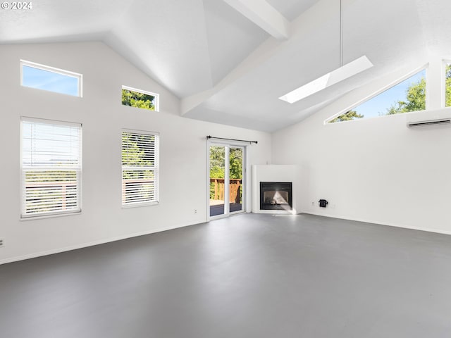 unfurnished living room featuring a skylight, high vaulted ceiling, and a wall unit AC