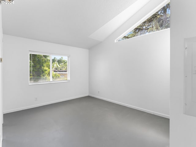 unfurnished room featuring lofted ceiling and electric panel