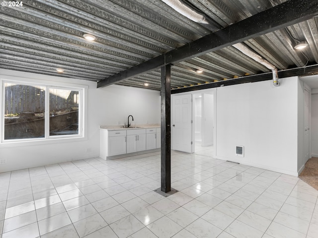 basement with sink and light tile patterned floors