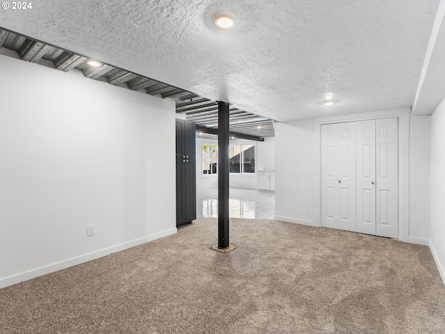 basement with carpet flooring and a textured ceiling