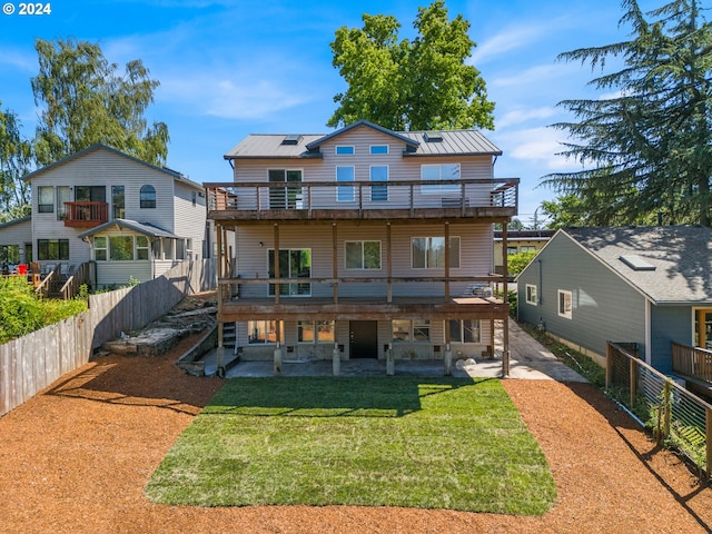 back of property featuring a yard, a patio area, and solar panels