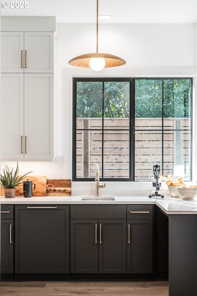 bar featuring a wealth of natural light, a sink, and wood finished floors