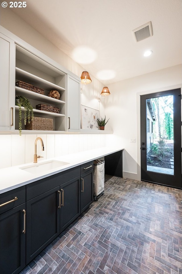 interior space with brick floor, recessed lighting, visible vents, and vanity