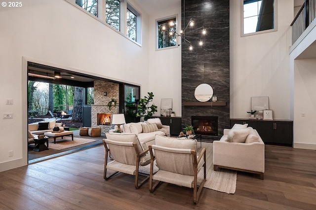 living area featuring a large fireplace, dark wood-style flooring, and a healthy amount of sunlight