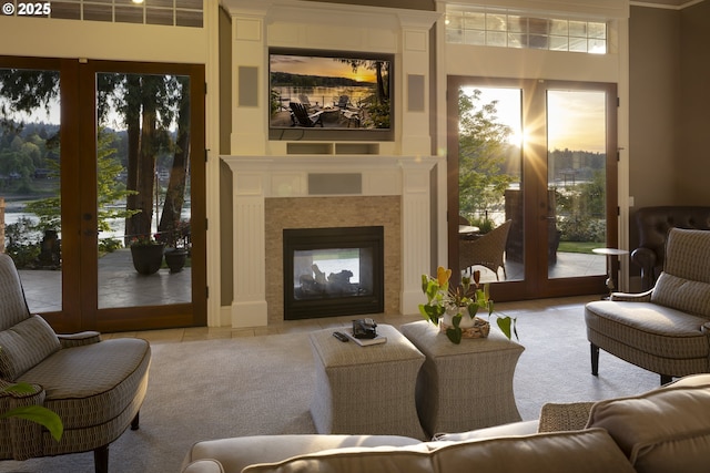sitting room featuring a tiled fireplace and french doors