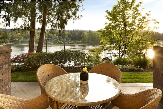 balcony featuring a patio, a water view, and outdoor dining area