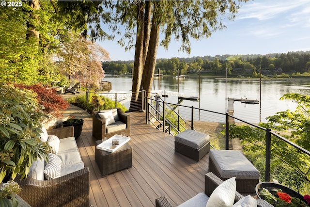 deck with a water view, a dock, and a forest view