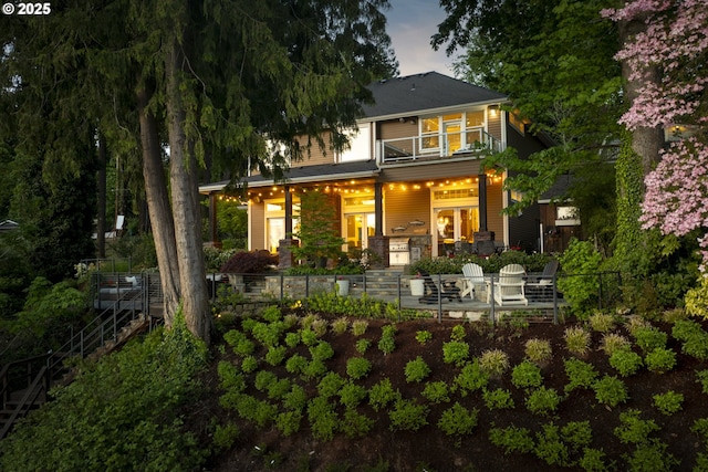 rear view of house with stairway and stone siding