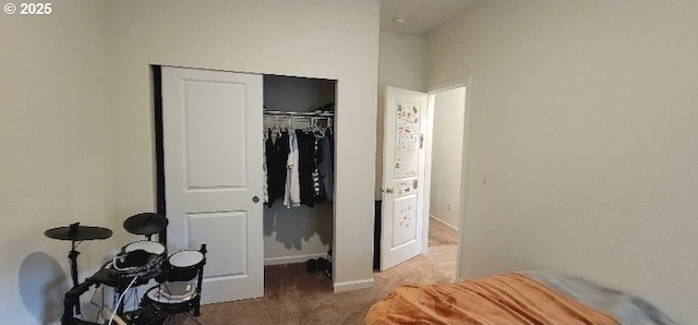 carpeted bedroom with a closet and baseboards