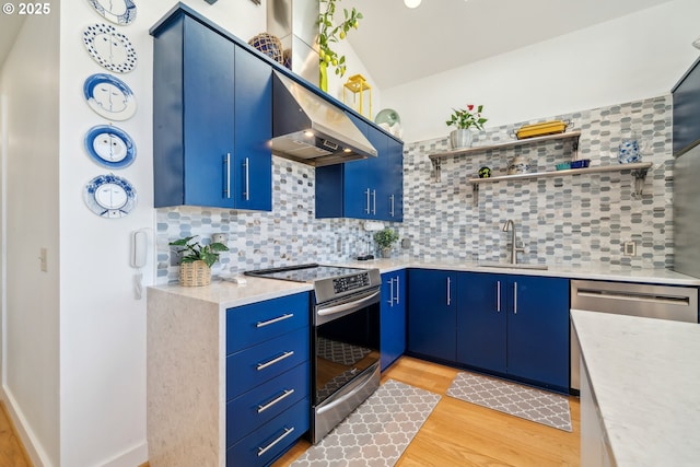26280 Beach Dr, Rockaway Beach, OR 97136 - kitchen featuring stainless steel appliances, blue cabinetry, backsplash, and light wood finished floors