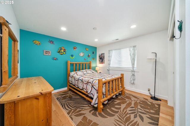 26280 Beach Dr, Rockaway Beach, OR 97136 - bedroom with wood finished floors, recessed lighting, and an accent wall