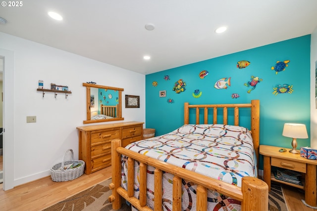 26280 Beach Dr, Rockaway Beach, OR 97136 - bedroom featuring wood finished floors, an accent wall, and recessed lighting