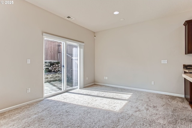 interior space featuring light colored carpet, visible vents, and baseboards