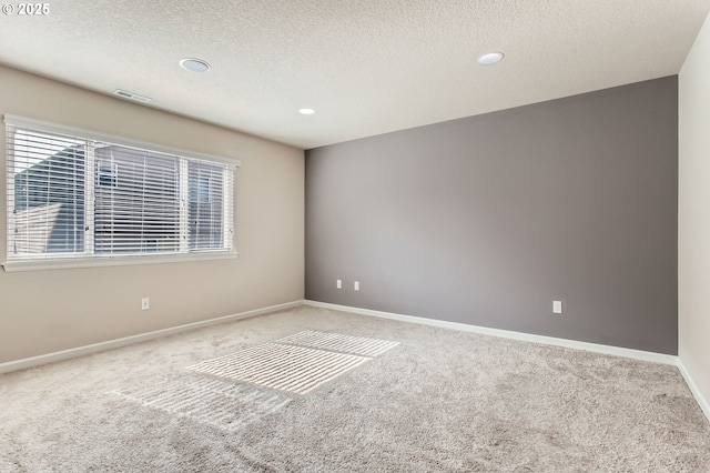 carpeted spare room featuring recessed lighting, visible vents, baseboards, and a textured ceiling