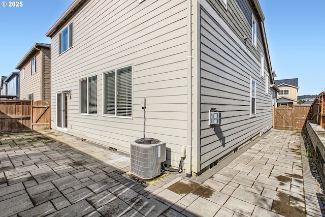 view of home's exterior featuring a patio area, central air condition unit, fence, and a gate