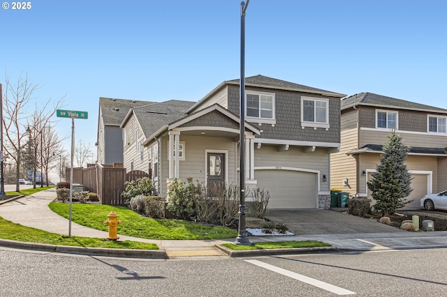 view of front facade with concrete driveway, fence, and a garage