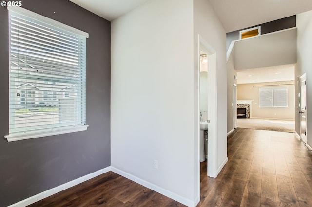 corridor featuring dark wood finished floors and baseboards