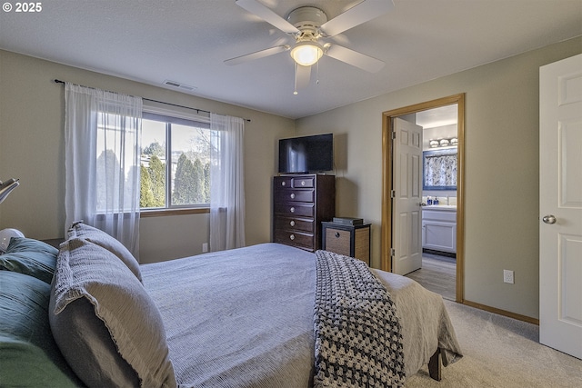 bedroom featuring ceiling fan, connected bathroom, and light carpet