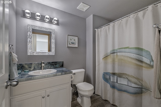 bathroom featuring wood-type flooring, toilet, and vanity