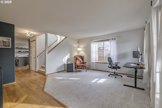 home office with hardwood / wood-style floors and a textured ceiling