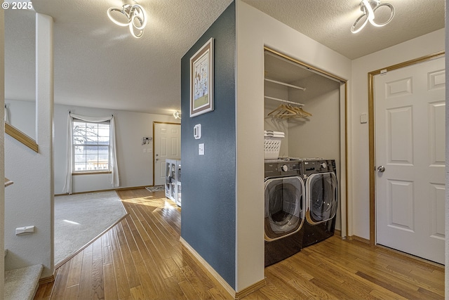 washroom featuring hardwood / wood-style flooring, a textured ceiling, and washer and dryer