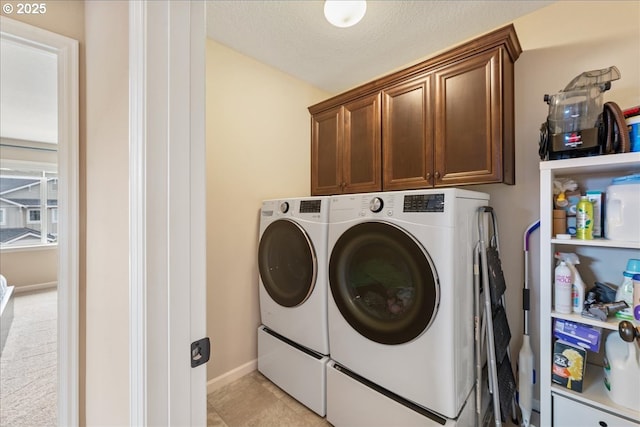 17202 NW Viola St, Portland, OR 97229 - laundry area featuring cabinet space, separate washer and dryer, baseboards, and a textured ceiling