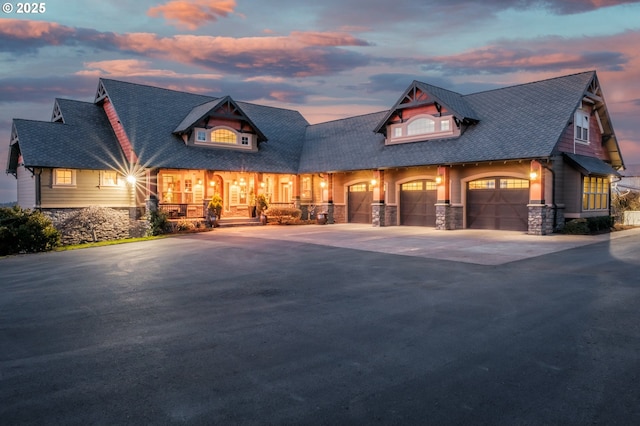 view of front of house with a garage, stone siding, and concrete driveway