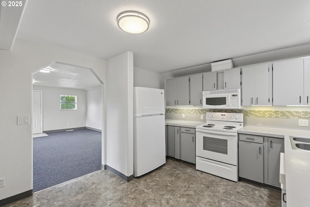 1570 Blaine St, Woodburn, OR 97071 - kitchen with white appliances, arched walkways, light countertops, and tasteful backsplash