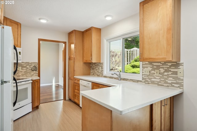 1904 Quinton St, The Dalles, OR 97058 - kitchen featuring white appliances, a sink, a peninsula, light wood-style flooring, and light countertops