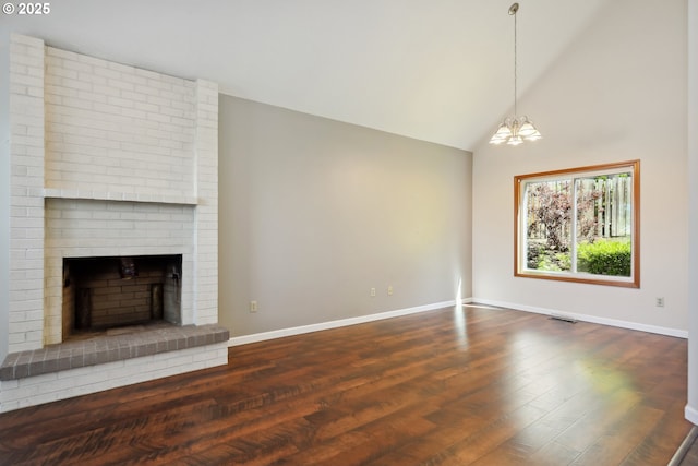 1904 Quinton St, The Dalles, OR 97058 - unfurnished living room with baseboards, a chandelier, dark wood-style floors, a brick fireplace, and high vaulted ceiling