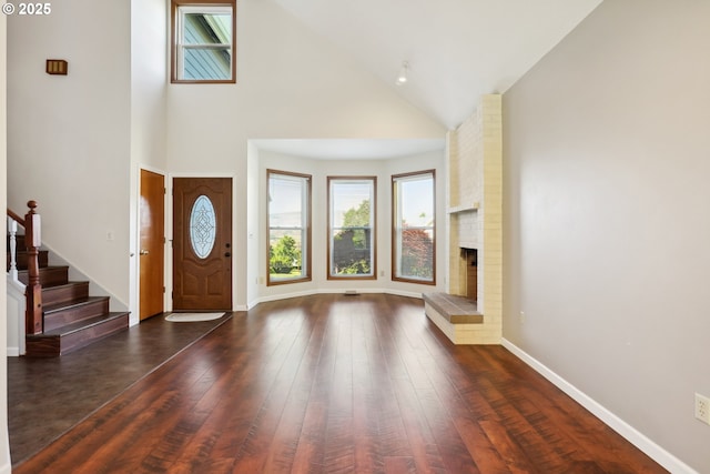 1904 Quinton St, The Dalles, OR 97058 - entrance foyer featuring high vaulted ceiling, dark wood-type flooring, stairway, baseboards, and a brick fireplace