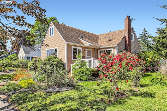 view of front of house featuring a chimney and a shingled roof